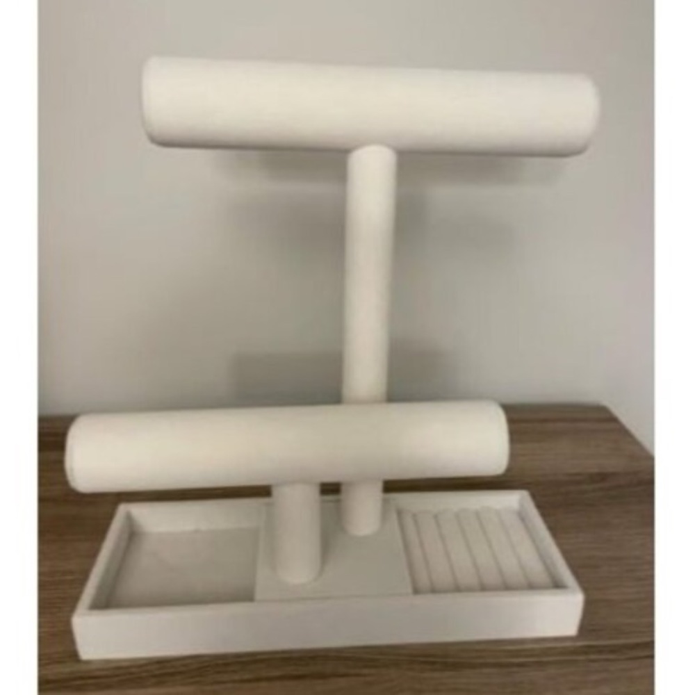 White jewelry stand with gold detailing.